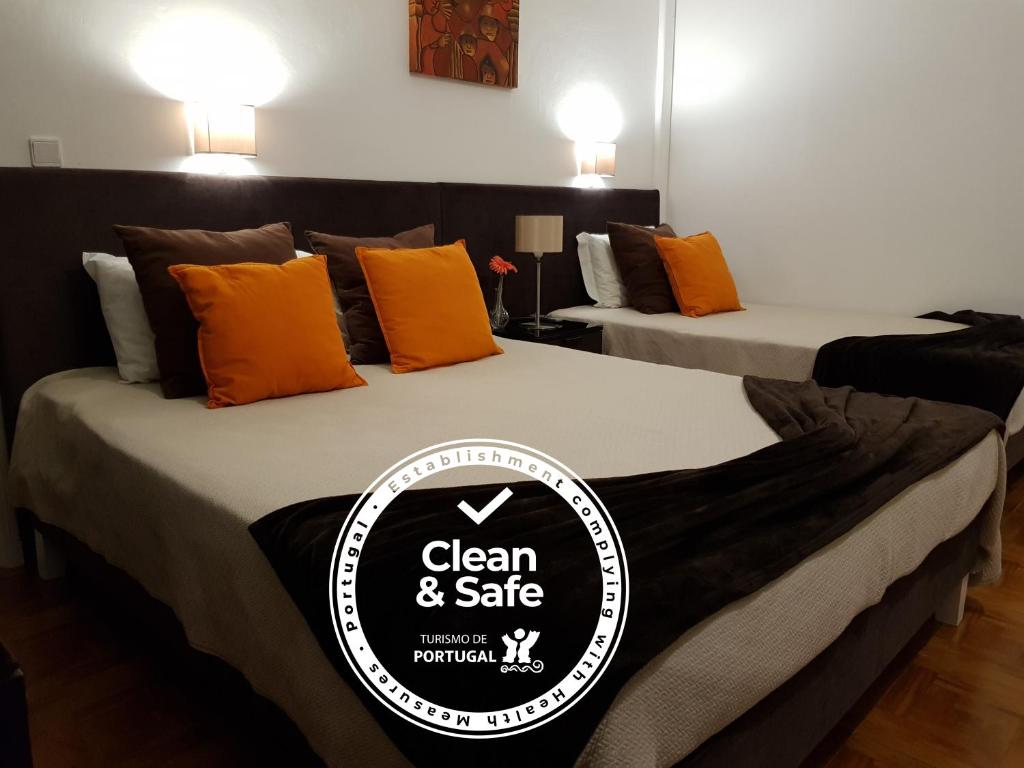 2 Betten mit einem Schild, auf dem sauber und sicher steht in der Unterkunft Alojamento Ar e Sol in Guimarães