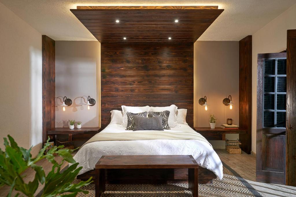 a bedroom with a large bed with a wooden headboard at H21 Hospedaje Boutique in Mexico City
