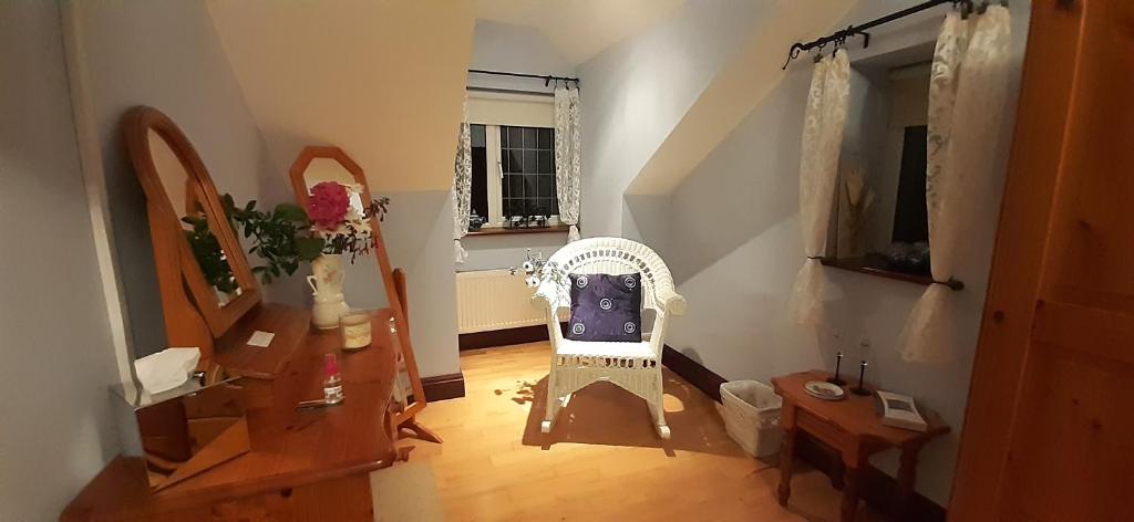 a living room with a white chair and a window at Creevagh (Room Only) in Keel