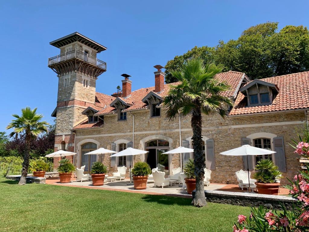 une maison avec des chaises et des parasols devant elle dans l'établissement Beaumanoir Small Luxury Boutique Hotel, à Biarritz