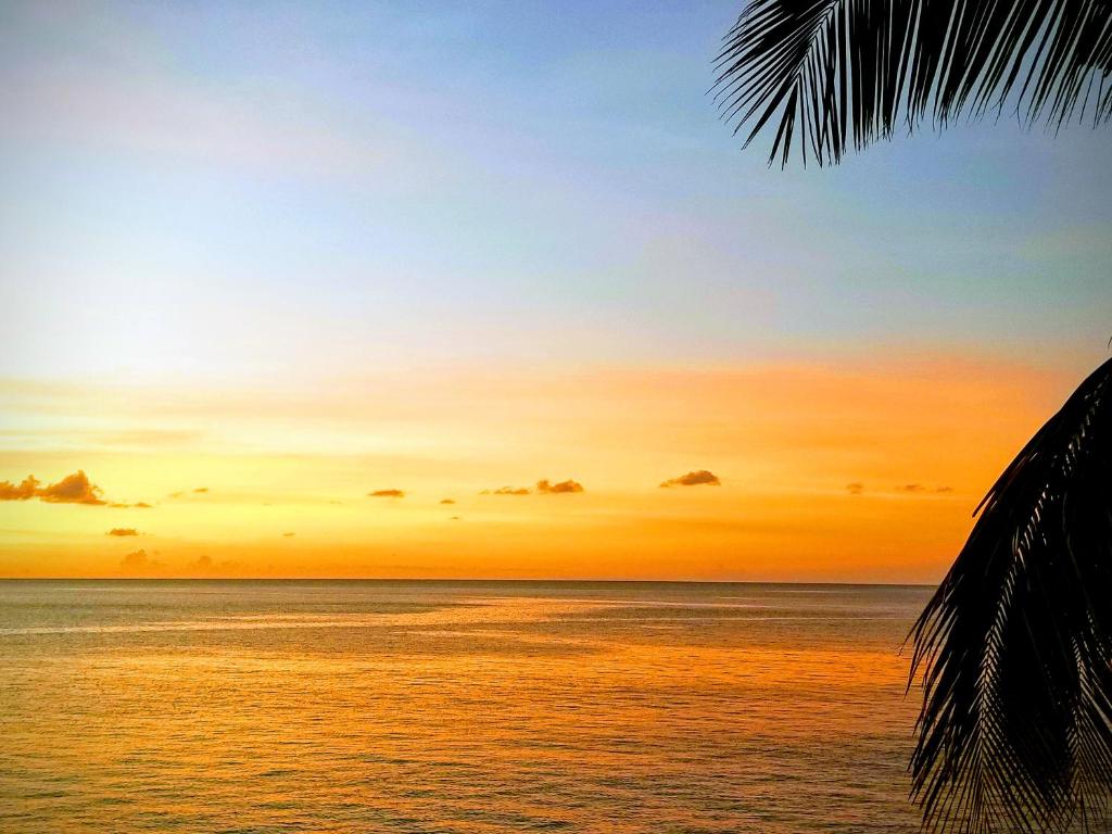 uma imagem de um pôr-do-sol sobre o oceano em Breathtaking View - Playa Lagun - Curacao em Lagun
