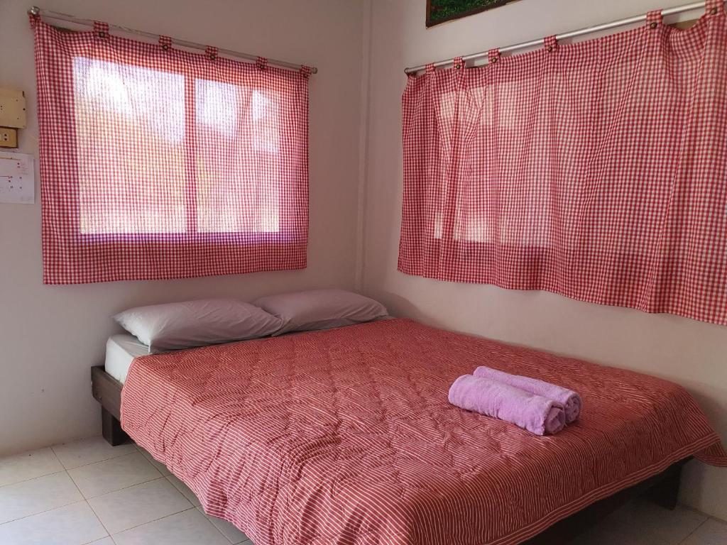 a bedroom with a bed with a red blanket and two windows at pineapple resort in Ban Huai Thalaeng Phan