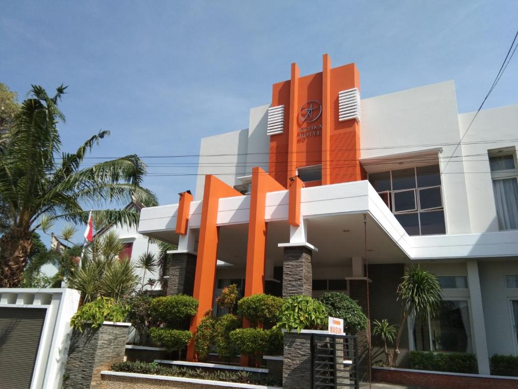 un edificio con alberi e alberi di orangefacto di fronte ad esso di Antika Hotel a Rembang