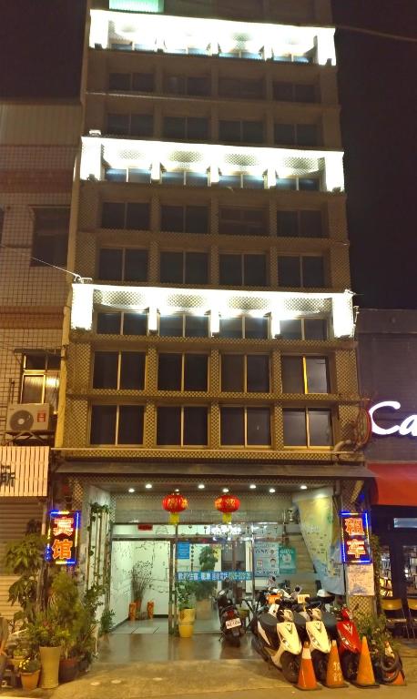 a large building with motorcycles parked in front of it at Kenting Heng-Chung Art Hostel in Hengchun