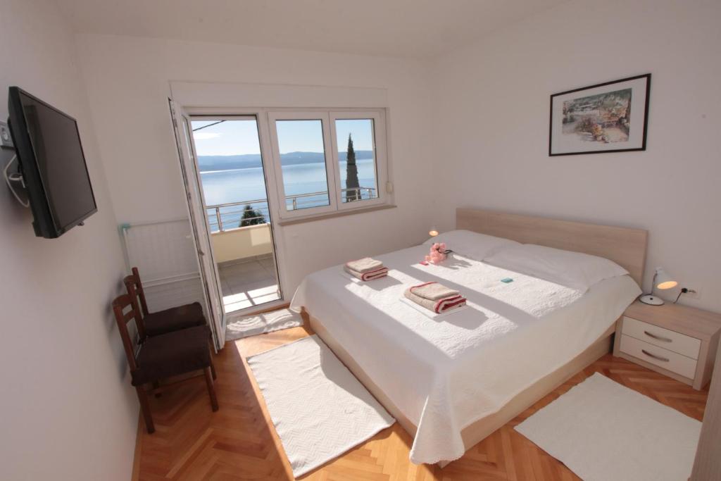 a small bedroom with a bed and a television at Apartmani Damir Livajić in Omiš