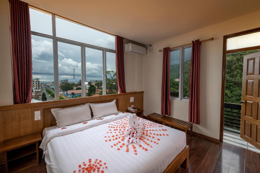 a bedroom with a large bed with red flowers on it at UCT Taunggyi Hotel in Taunggyi