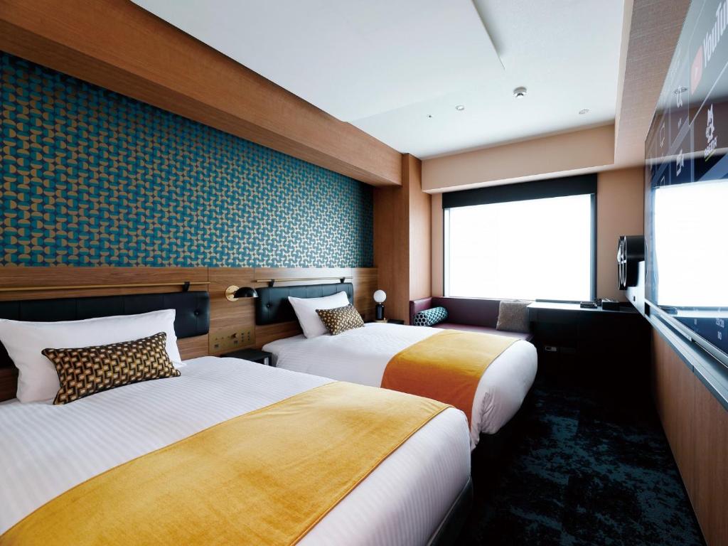 Un pat sau paturi într-o cameră la DEL style Osaka Shin Umeda by Daiwa Roynet Hotel