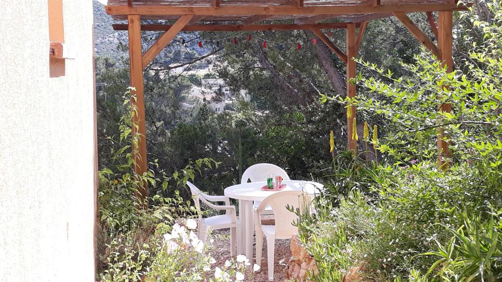 a table and chairs sitting under a wooden pergola at Galinette in Peypin