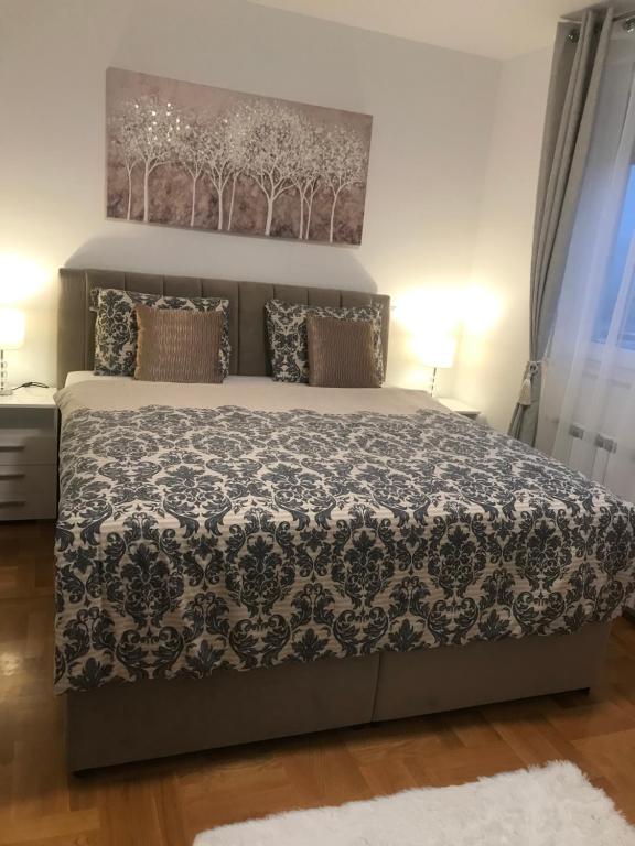 een slaapkamer met een bed met een zwart-witte sprei bij Luna Apartments, apartments with style in Zagreb