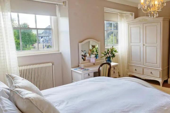 - une chambre avec un lit et un bureau avec un miroir dans l'établissement No 6 The Square Tearooms & Accommodation, à Buxton