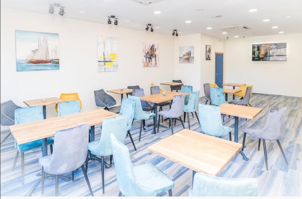 a restaurant with wooden tables and blue chairs at AI HOSTEL in Split