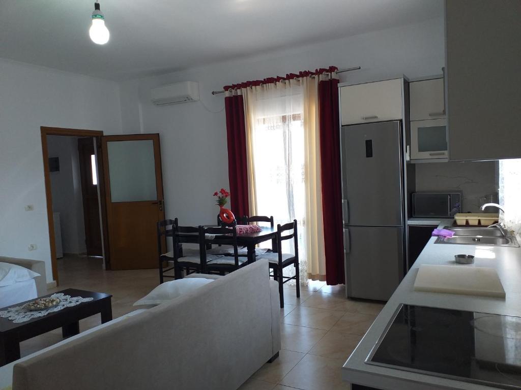 a living room with a couch and a table with chairs at Grand Seaview Apartments in Ksamil