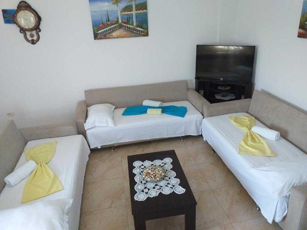 a living room with two couches and a tv at Grand Seaview Apartments in Ksamil