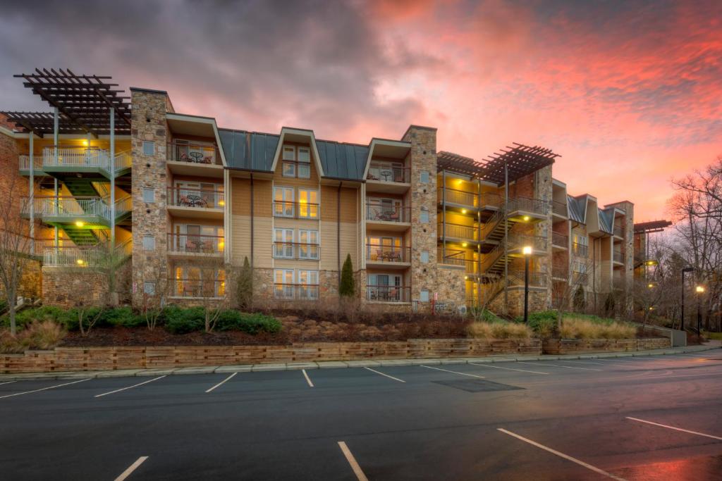 an apartment building with a parking lot at sunset at The Residences at Biltmore - Asheville in Asheville