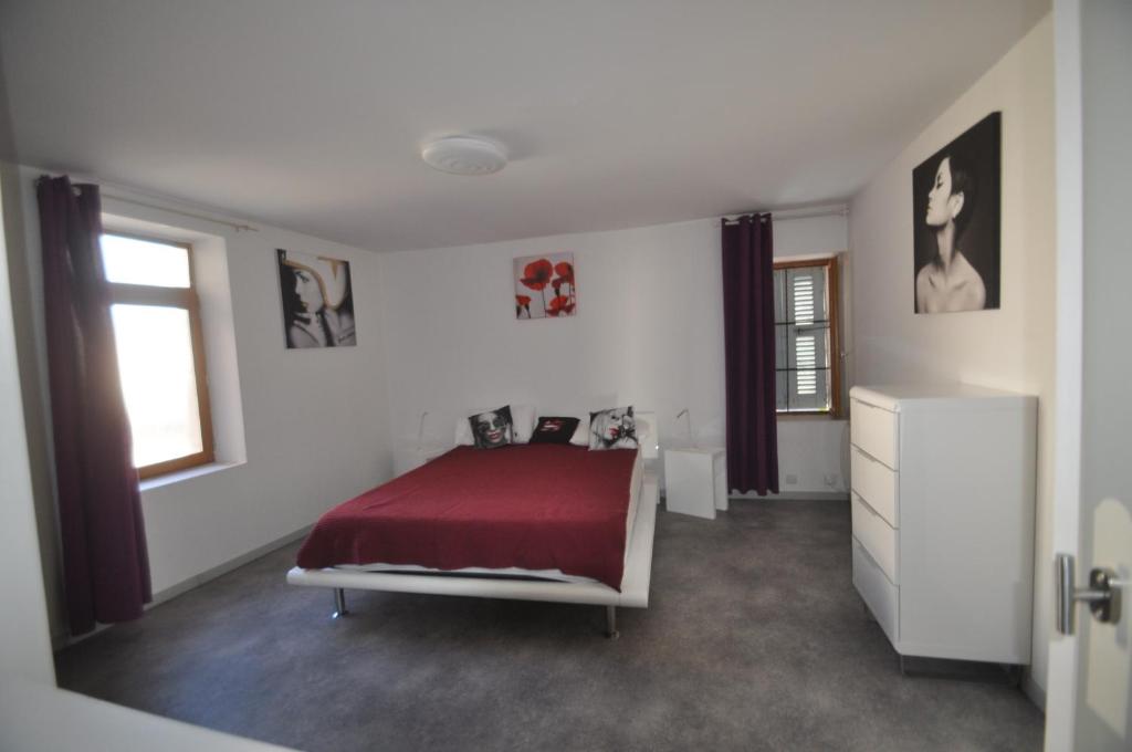 a white bedroom with a bed with a red blanket at sassenage au pied du Vercors 2 appartements in Sassenage