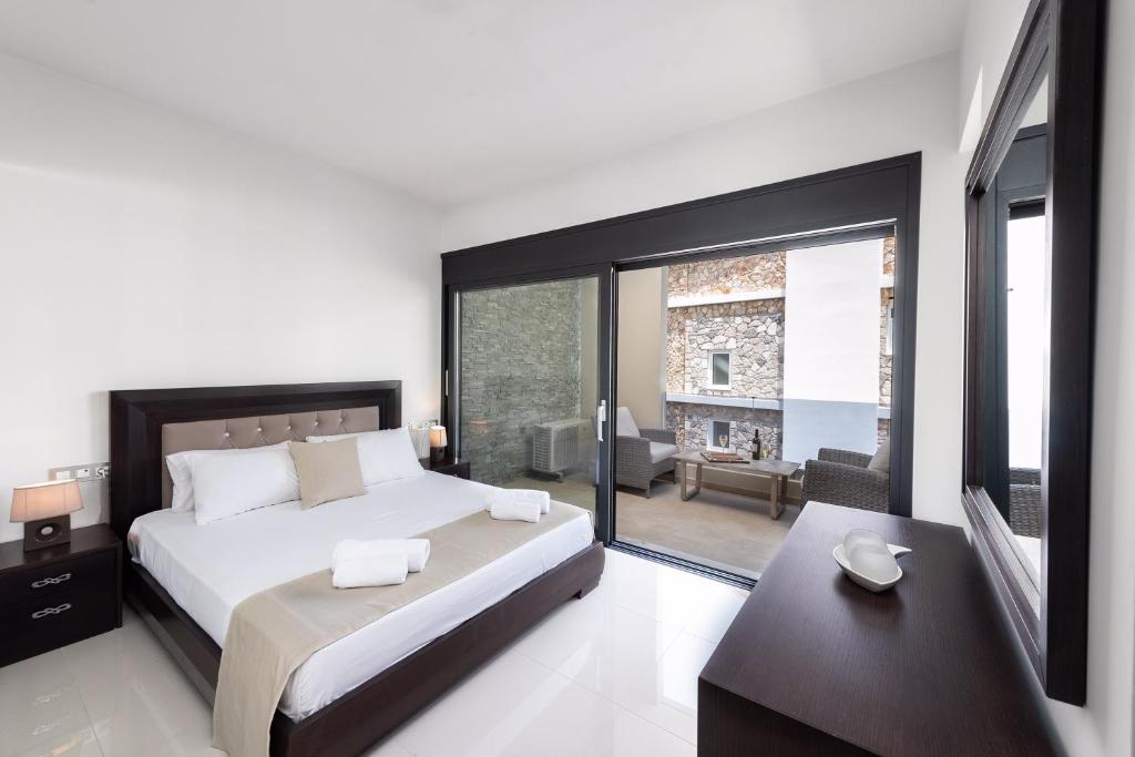 een slaapkamer met een groot bed en een groot raam bij Ixia Breeze 2 in Ixia