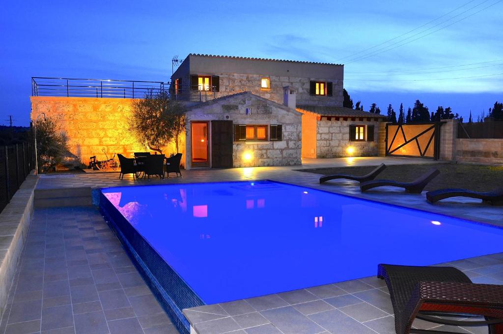 une grande piscine bleue en face d'une maison dans l'établissement Son Ramon, à Muro