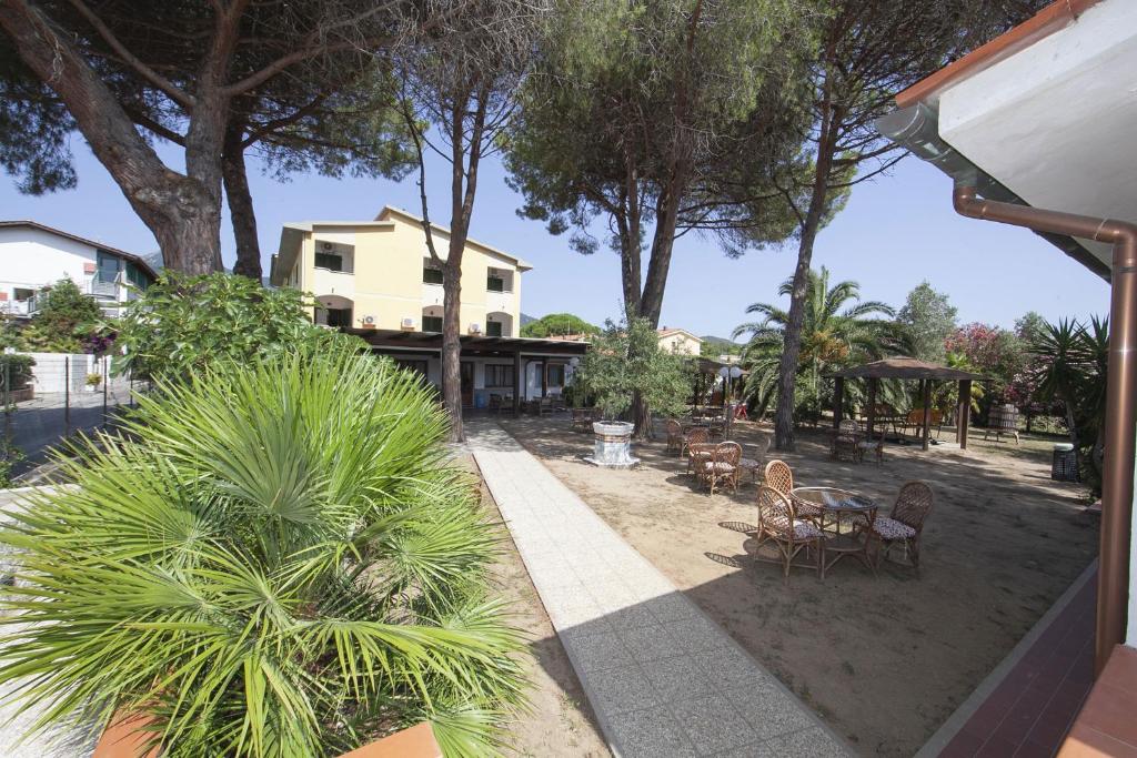 a view of a yard with chairs and a house at Hotel Santa Caterina in Marina di Campo
