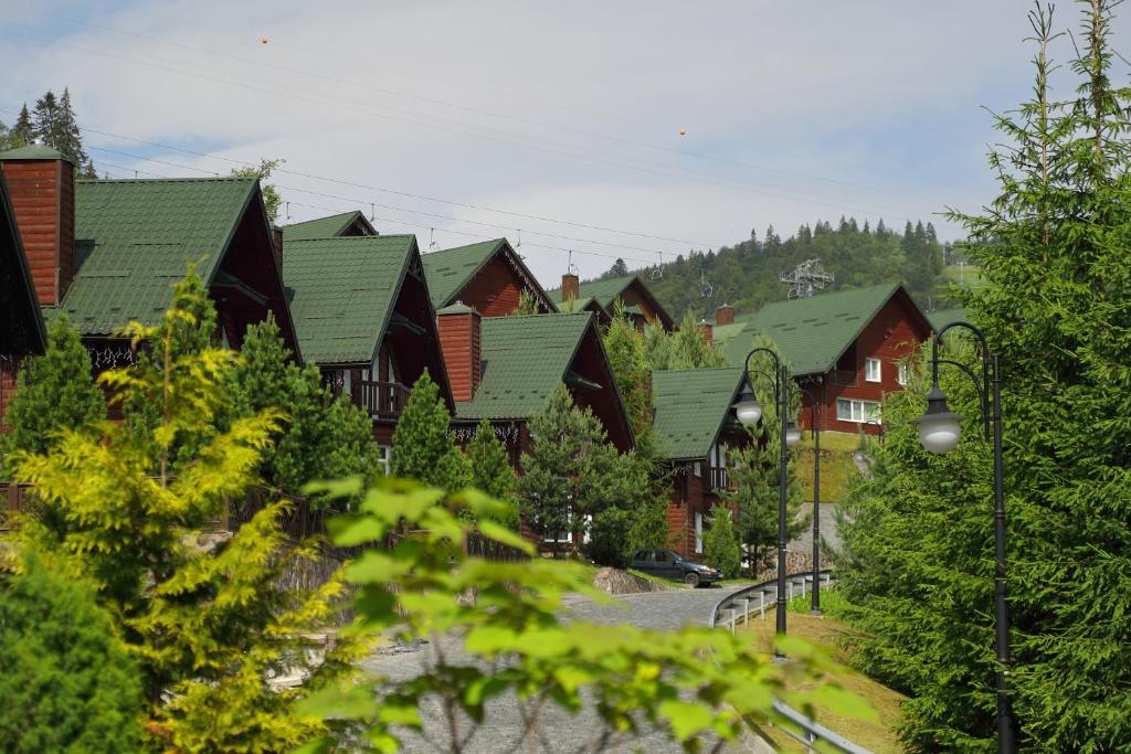 a row of houses with green roofs at Bukovel Hotel in Bukovel