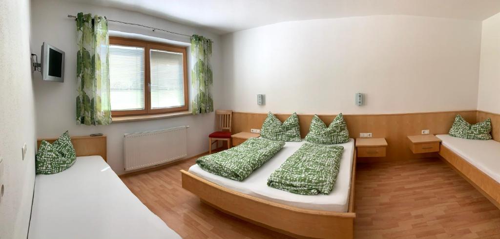 a bedroom with two beds with green pillows at Appartements Samerhof - TOP 1 in Kaltenbach