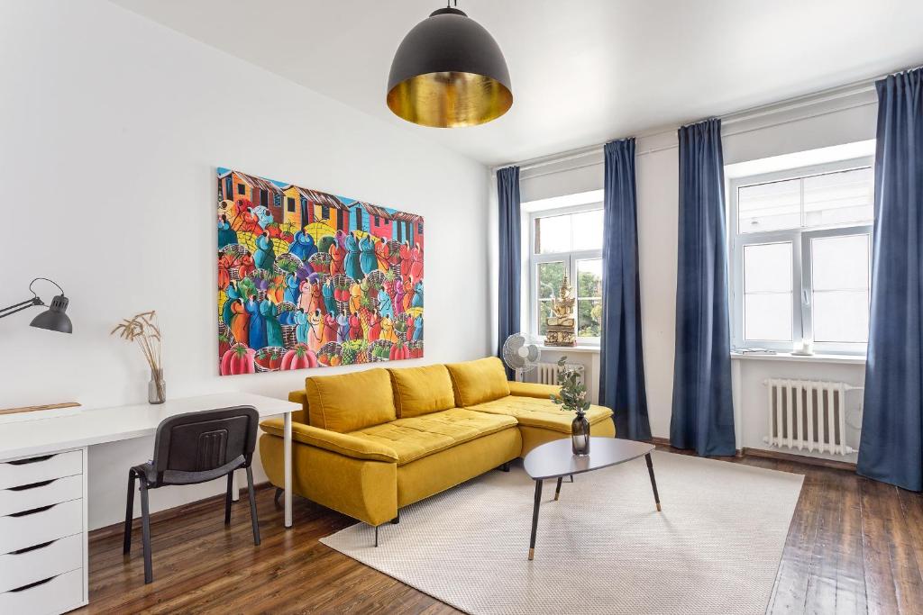 a living room with a yellow couch and a table at New Quiet Cozy City Center apartment in Vilnius