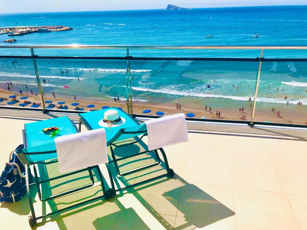 2 sillas sentadas en un balcón con vistas a la playa en Hotel Marconi, en Benidorm