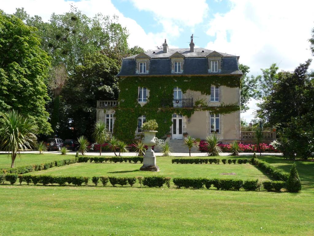 Una casa grande con un jardín enfrente. en Manoir de la Marjolaine, en Cabourg