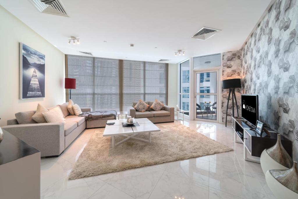 a living room with a couch and a table at Hometown Apartments - Luxury and Spacious 3 bedroom apartment in Marina in Dubai