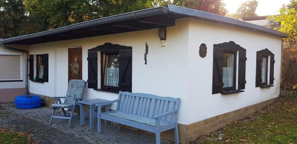 una piccola casa con una panchina blu e un tavolo di Haus Andrea a Lichtenberg