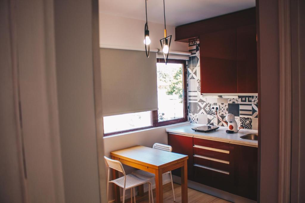 una pequeña cocina con una mesa de madera y una ventana en Apartamento Torreão, en Póvoa de Varzim
