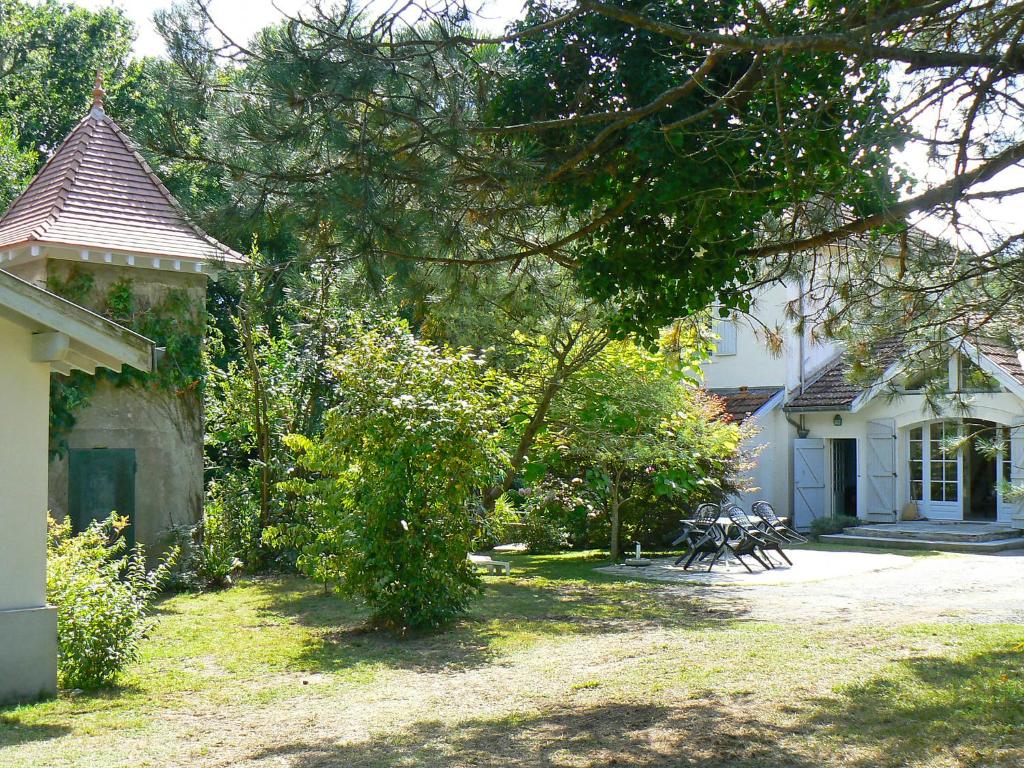 a yard of a house with a tree and a building at Holiday Home Le chant des milans by Interhome in Ondres