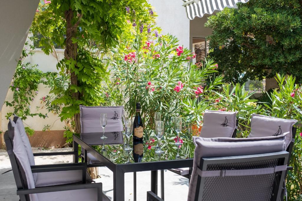 einen Tisch und Stühle in einem Garten mit Blumen in der Unterkunft Apartments Sky in Vodice