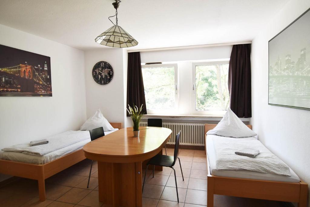 Zimmer mit einem Tisch, einem Bett und einem Schreibtisch in der Unterkunft Köln Höhenberg in Köln