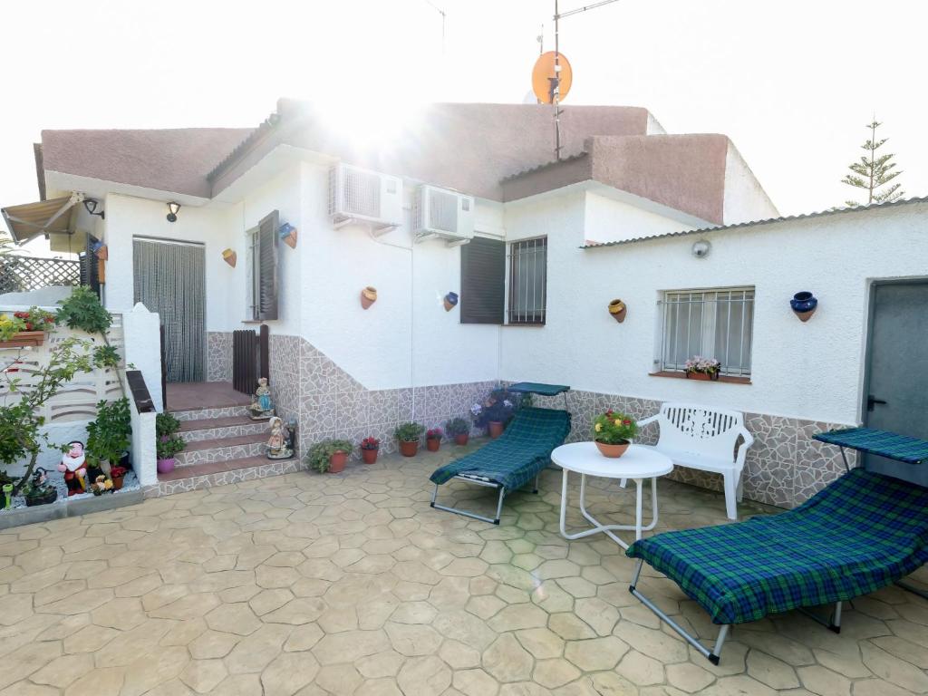 a patio with chairs and a table and a house at Holiday Home Coquetó by Interhome in Riumar