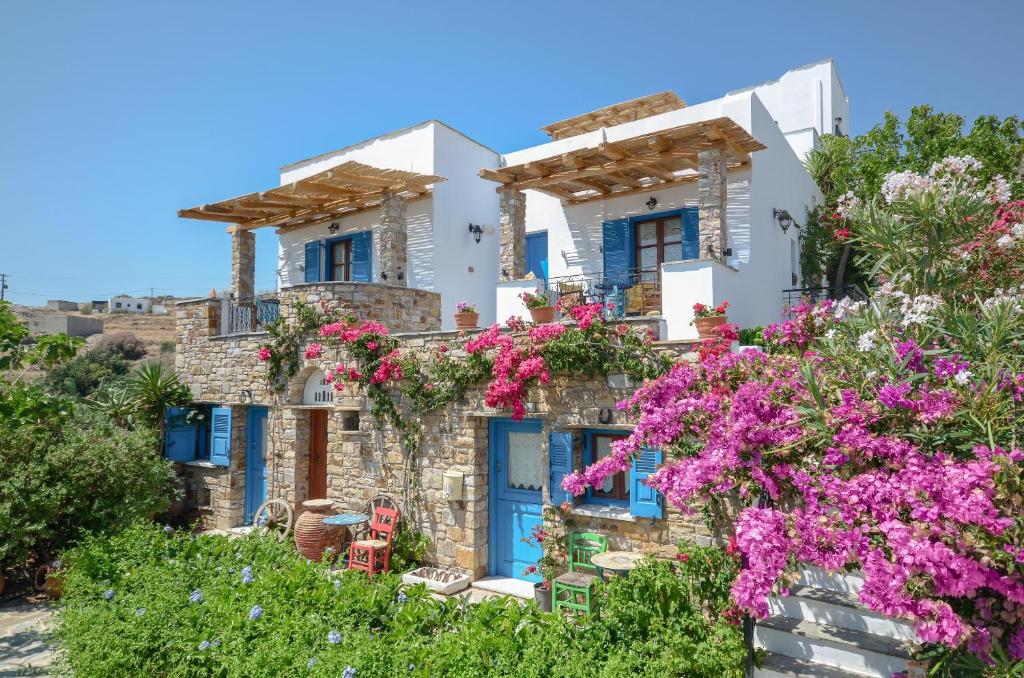 Naxos Filoxenia Hotel في Galini: منزل به أبواب زرقاء وورود