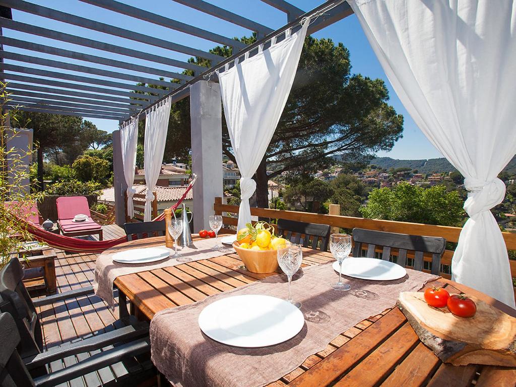 a wooden table with a bowl of fruit on a patio at Holiday Home Ginesteres by Interhome in Argentona