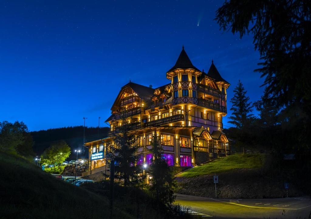 a large house is lit up at night at Grand Hotel**** Bachledka Strachan in Ždiar