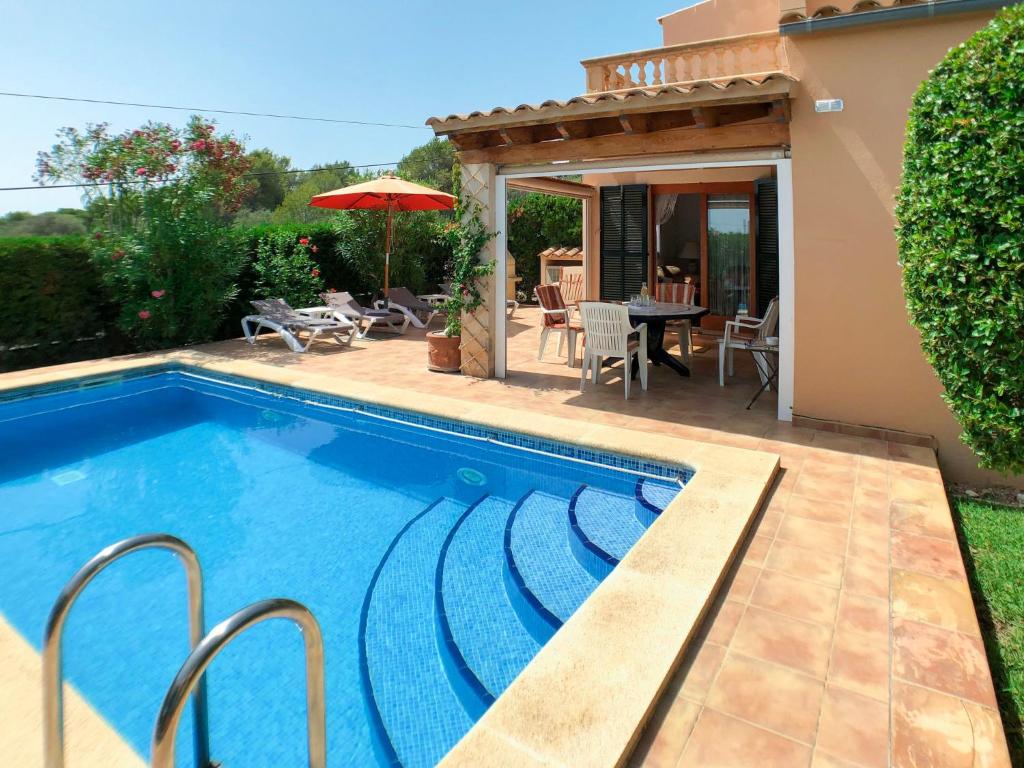 - une piscine en face d'une maison avec une terrasse dans l'établissement Holiday Home Schnuffi - PCN155 by Interhome, à Porto Cristo