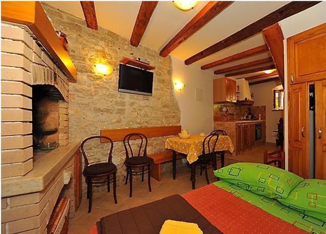 ein Wohnzimmer mit einem Tisch und einem Steinkamin in der Unterkunft Studios Dalino in Rovinj
