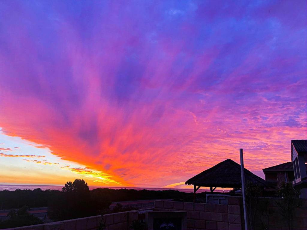 un coucher de soleil avec des nuages colorés dans le ciel dans l'établissement Ocean Reef Vista, à Perth