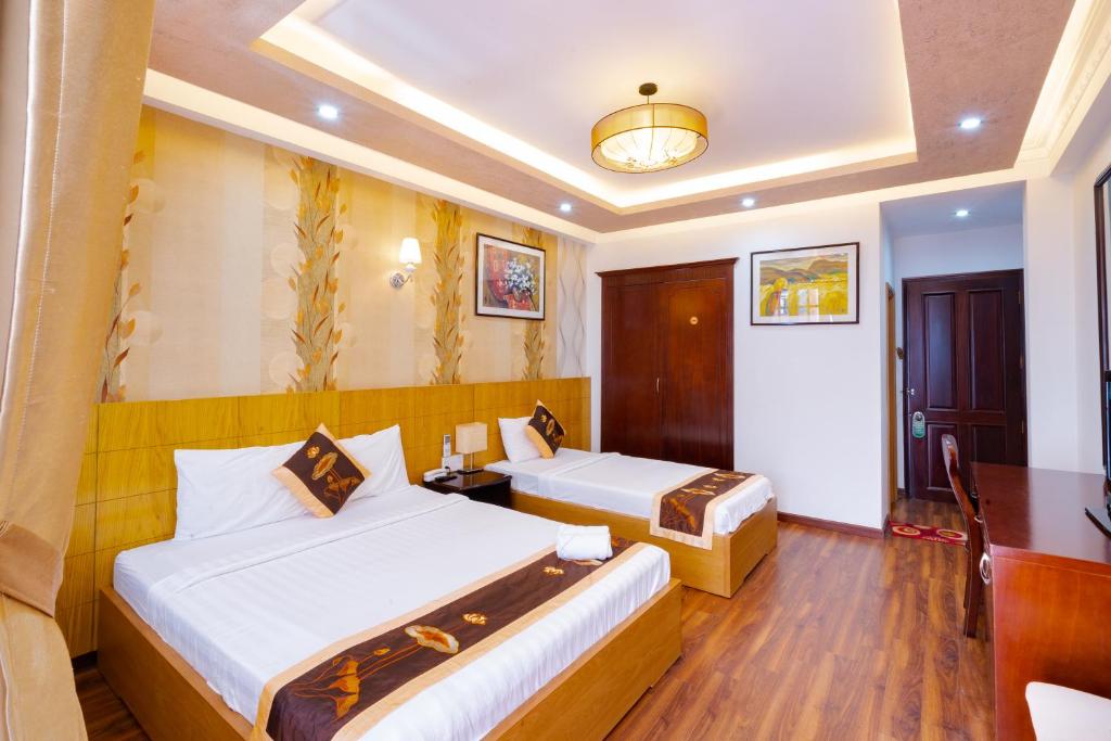 Saigon Amigo Hotel في مدينة هوشي منه: غرفة فندقية بسريرين وطاولة