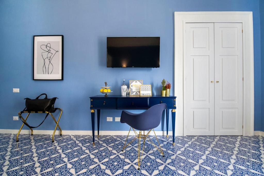 ein blaues Zimmer mit einem blauen Schreibtisch und einem Stuhl in der Unterkunft Crudo Home in Pompei