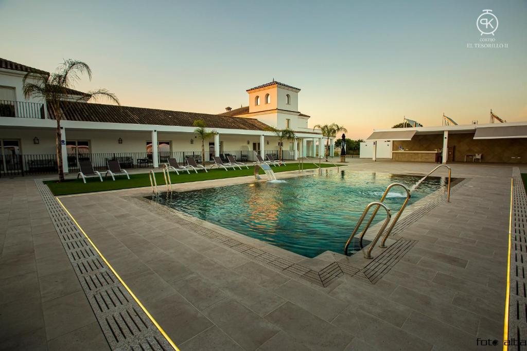 a building with a swimming pool in front of a building at El Tesorillo II in Arcos de la Frontera