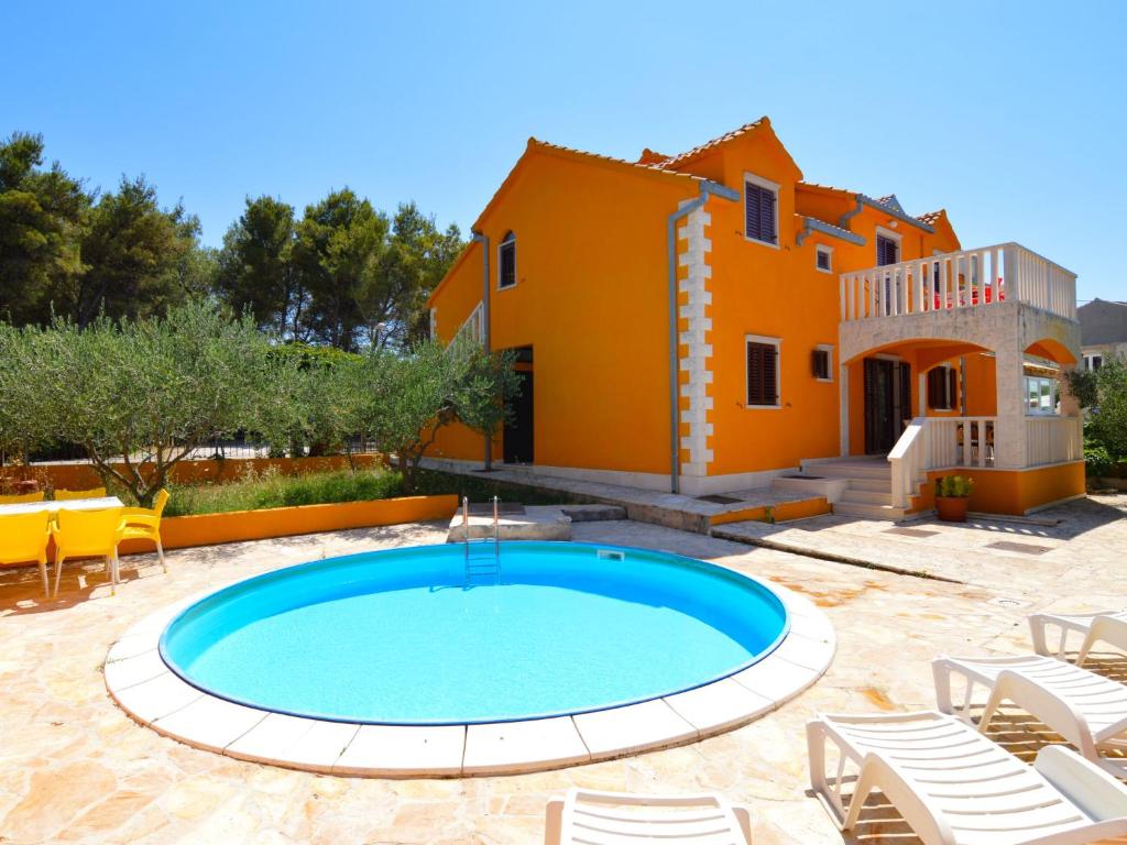 a villa with a swimming pool in front of a house at Holiday Home Gorana - BRC152 by Interhome in Mirce