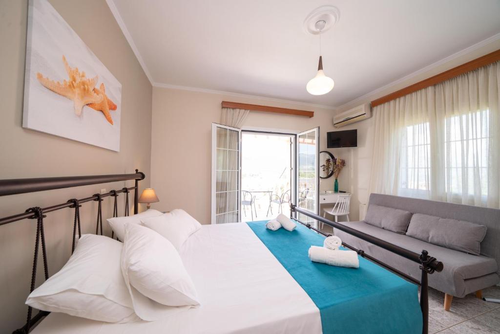 una camera con un grande letto e un divano di Pavlatos Apartments & Studios a Sami