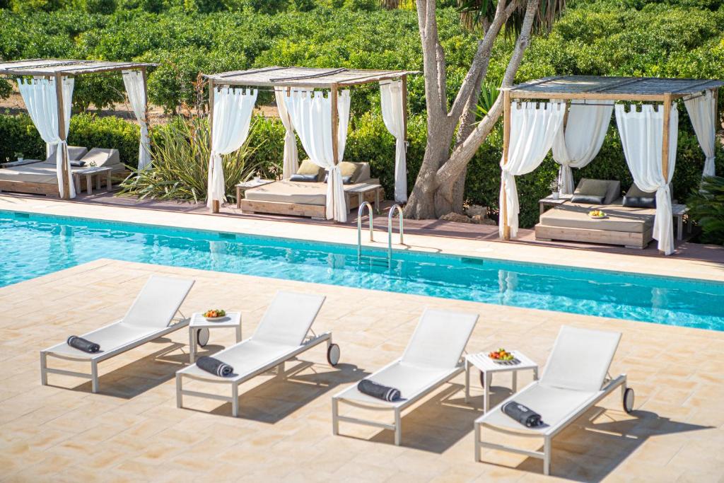 a pool with lounge chairs and a gazebo at Can Jaume by Ocean Drive in Ibiza Town