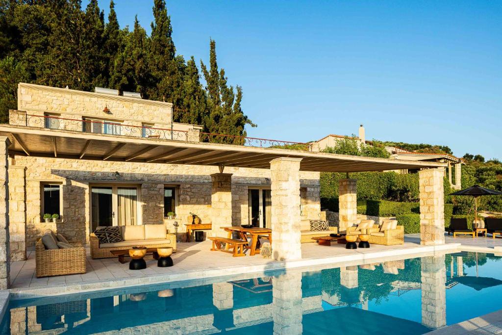 a house with a swimming pool next to a building at Villa Mantilari Wine Estate 7 Apartments 2 Private Pools 1 Heated Tennis Court Fitness Center in Archanes