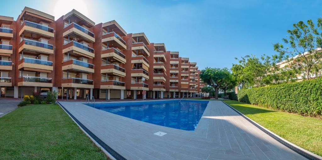an apartment complex with a swimming pool in front of a building at Apartaments Voralmar - Mas d'en Gran in Cambrils