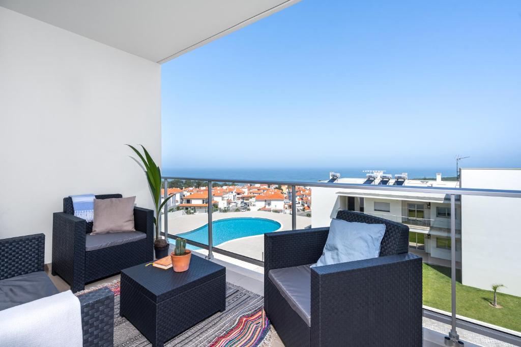 uma varanda com mobiliário e vista para o oceano em Private Condominium, Pool, Tennis & Sea View by Silver Prop em Nazaré