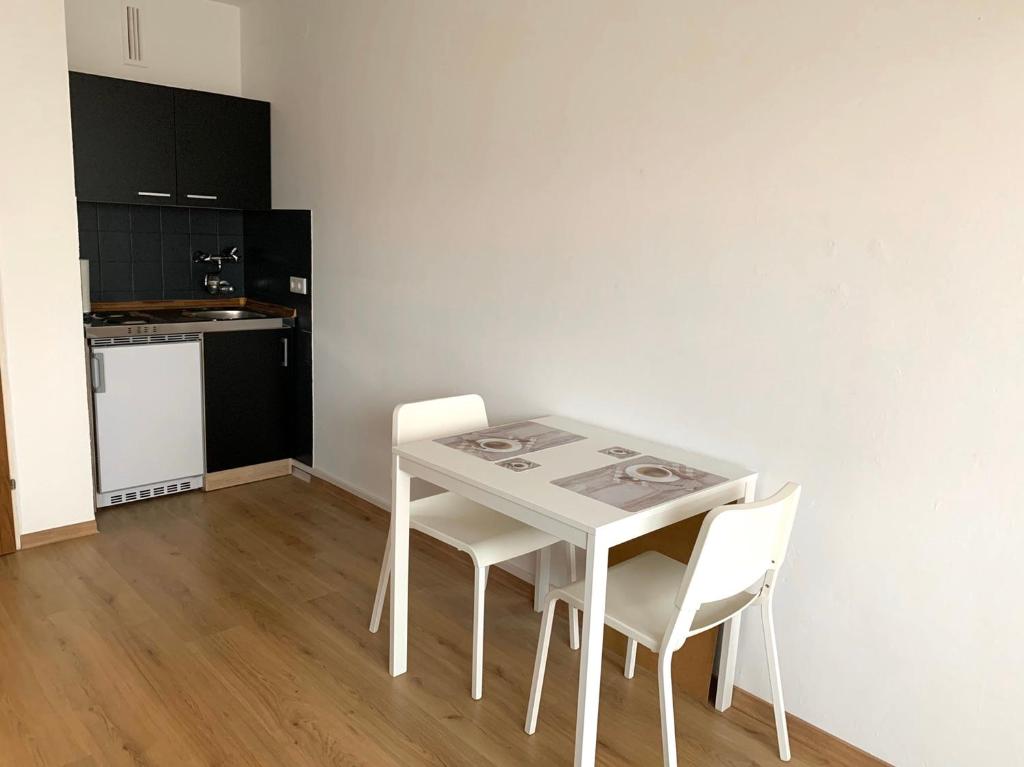 a white table and chairs in a room with a kitchen at Renoviert, modern und ruhig in Nuremberg